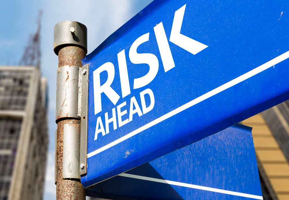 Blue sign post with "Risk Ahead" printed across it.